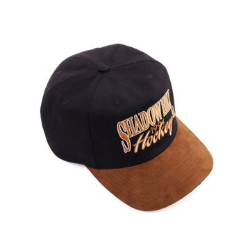 Black and brown Shadow Hill Hockey cap with gold embroidered text reading "Shadow Hill 1994 Hockey